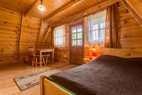 a bedroom with a bed in a log cabin at DOMKI u JÓZKA in Polańczyk