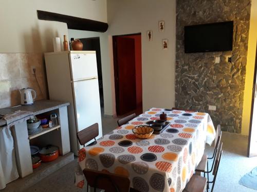 a kitchen with a table and a refrigerator at Casa Manipa -3 dormitorios in Cafayate