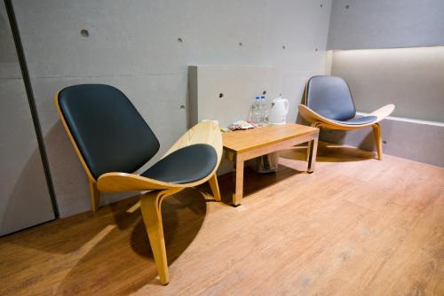 two chairs and a table in a room at Hotel Shumei Chiayi in Zhongpu
