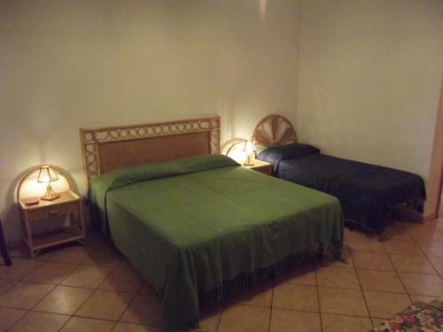 a bedroom with two beds and two lamps on tables at L'Oasi di Recale in Scauri