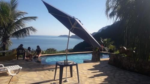 a swimming pool with a view of the ocean at Vila Lia in São Sebastião