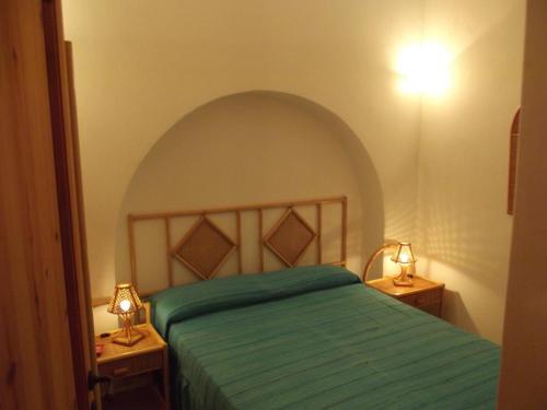 1 dormitorio con 1 cama verde y 2 mesitas de noche en L'Oasi di Recale, en Scauri