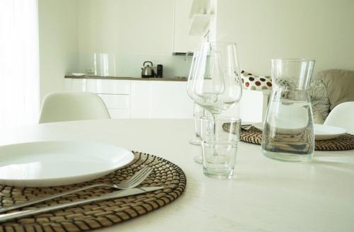 a white table with glasses and plates on it at Casa Sisu - Apartment in Bergamo