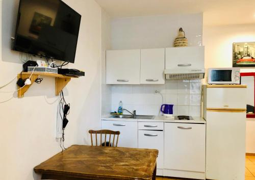 a small kitchen with a white refrigerator and a table at Beaux studios sur les quais in Alfortville