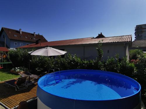 a swimming pool with a blue umbrella on top of it at Studios + in Graz