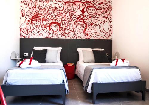 dwa łóżka w pokoju z obrazem na ścianie w obiekcie House of Arts w mieście Montelupo Fiorentino