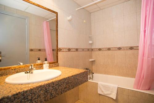 a bathroom with a sink and a tub and a mirror at Hotel Villa Barbara in Can Picafort
