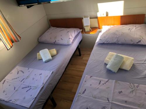 two beds in a small room with purple sheets at Petra's garden in Kraj