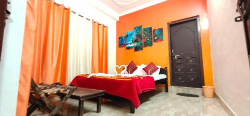 a room with a bed with an orange wall at Haveli Taragarh Palace in Būndi
