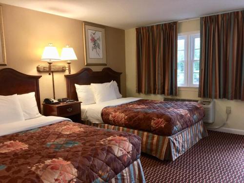 A bed or beds in a room at Scottish Inns Sturbridge