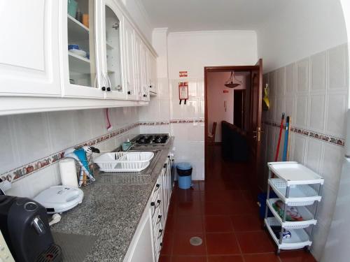 a kitchen with white cabinets and a counter top at Refugio das Matas in Porto Santo