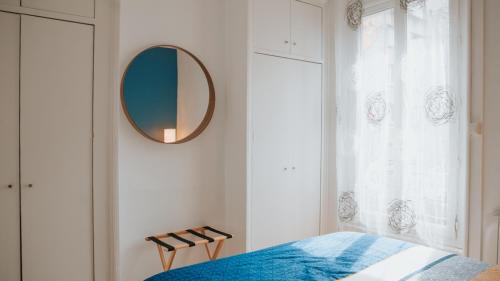 1 dormitorio con cama y espejo en la pared en Appartement écologique - Proche Métro Charpennes, en Villeurbanne