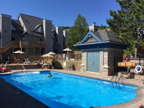 a person swimming in a large blue swimming pool at Blue Mountain (1 bedroom) Escape at North Creek Resort in Blue Mountains