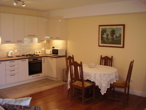 a kitchen with a table and chairs and a kitchen with white cabinets at Water view brand new Apartment, short stroll to beach, peaceful! in Košljun