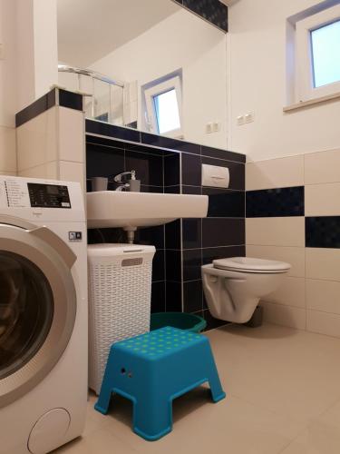 a bathroom with a sink and a washing machine at Cozy apartments with seafront terraces in Omiš