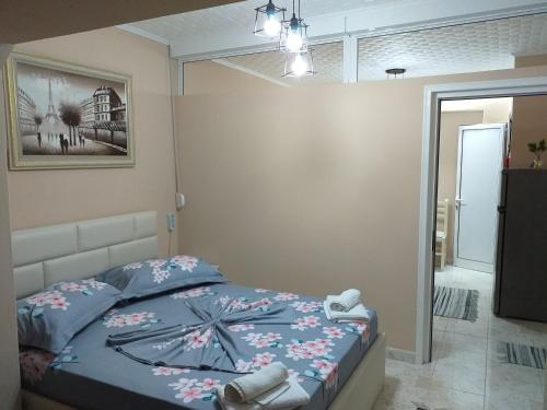 een slaapkamer met een bed en een foto aan de muur bij Friendly Apartment in Shkodër