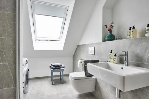 a bathroom with a sink and a toilet and a window at Boardinghome Oldenburg in Oldenburg