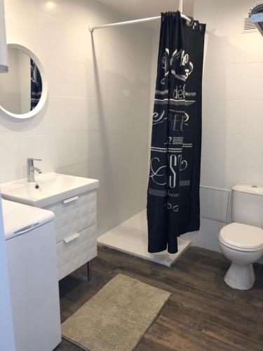 La salle de bains est pourvue de toilettes et d'un rideau de douche. dans l'établissement Appartement Vue Mer climatisé 2 chambres, à Port-la-Nouvelle