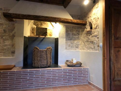 a fireplace in a room with a brick wall at CAL PUIG, ENOTURISMO RURAL entre Viñas y Bosques in Juncosa
