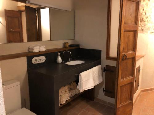 a bathroom with a black sink and a mirror at CAL PUIG, ENOTURISMO RURAL entre Viñas y Bosques in Juncosa