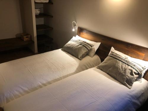 a bedroom with two beds with white sheets and pillows at CAL PUIG, ENOTURISMO RURAL entre Viñas y Bosques in Juncosa