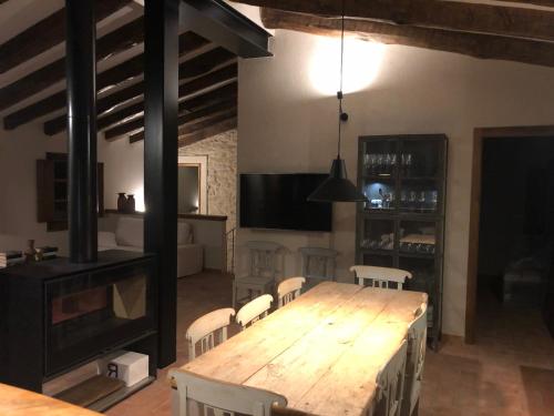 a dining room with a wooden table and chairs at CAL PUIG, ENOTURISMO RURAL entre Viñas y Bosques in Juncosa