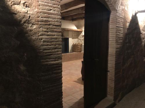 an open door to a kitchen with a brick wall at CAL PUIG, ENOTURISMO RURAL entre Viñas y Bosques in Juncosa