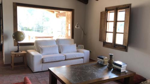 a living room with a couch and a coffee table at CAL PUIG, ENOTURISMO RURAL entre Viñas y Bosques in Juncosa