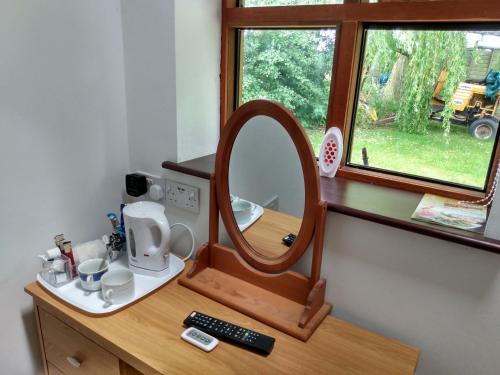 a vanity with a mirror on a wooden dresser at Brook Barn B&B in Hale