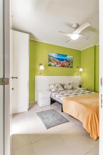 a green bedroom with a bed and a ceiling fan at Apartamento en Alcalá, con aparcamento, con aircondicionador in Alcalá