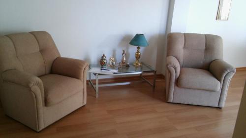 two chairs and a table in a living room at KURMI in Olavarría