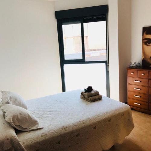 ein Schlafzimmer mit einem Bett, einer Kommode und einem Fenster in der Unterkunft La Caixeta in Vinarós