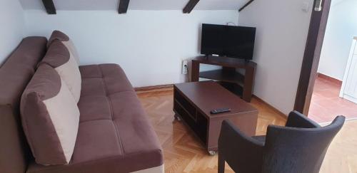 a living room with a couch and a tv at Apartmani Kovačević in Kotor