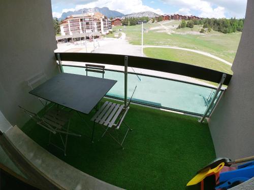 d'un balcon avec une table, des chaises et une piscine. dans l'établissement Studio Yomeo - La Joue Du Loup - Pied des pistes - 30M2 1 à 5 personnes, à La Joue du Loup