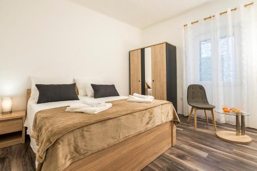 a bedroom with a large bed and a chair at Rooftop city view apartment in the palace walls in Split