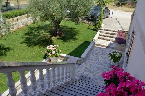 a balcony with a white railing and a yard with flowers at Room Kris with private entrance & private bathroom in Umag