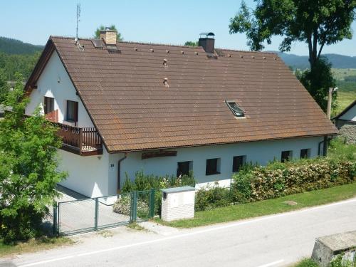 a large white house with a brown roof at Pod Smrcinou in Nová Pec