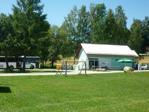 a shed with two swings in a grass field at Pod Smrcinou in Nová Pec