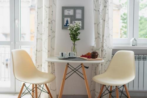 duas cadeiras e uma mesa num quarto com cortinas em Emilii Plater 12 Prywatne mieszkanie z balkonem 400 m od Dworca Centralnego em Varsóvia