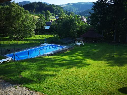 a large yard with a swimming pool in the grass at Mylak BIANCA in Korbielów