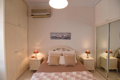 ein Schlafzimmer mit einem Bett mit zwei Nachttischen und zwei Lampen in der Unterkunft Relaxing House in Kavala