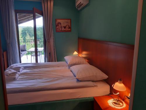 1 cama con 2 almohadas y 1 ventana en el dormitorio en Rooms Leban, en Šempas
