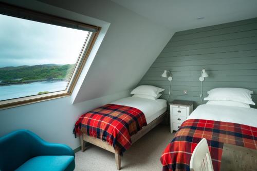 a bedroom with two beds and a window at Tor Druim in Drumbeg