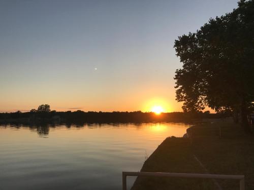 a sunset over a body of water with the sun setting at Oasis Lake Buchanan in Bluffton