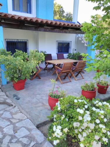 a patio with a wooden table and potted plants at Villa Elpida in Kanali