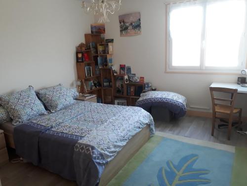 a bedroom with a bed and a desk and a window at L'Escale in Rochefort