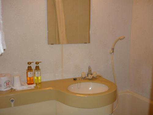 y baño con lavabo y espejo. en Takada Terminal Hotel, en Joetsu