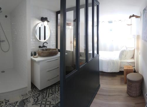 a bathroom with a sink and a mirror at Nos Îles in Saint-Jean-de-Monts