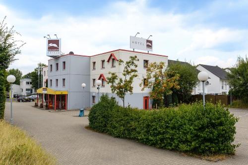 a white building with a sign on top of it at bon marché hôtel Bochum in Bochum