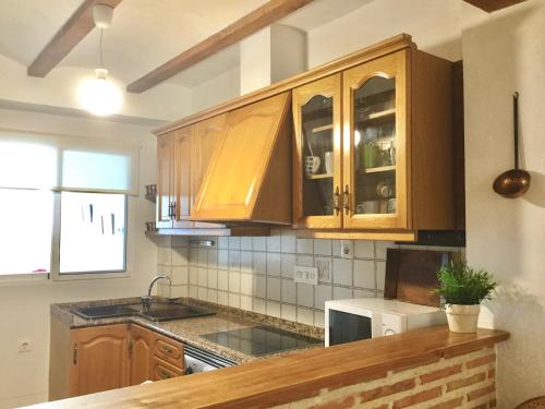 a kitchen with wooden cabinets and a counter top at Alto Palancia Calle Progreso 25 Sot de Ferrer in Sot de Ferrer